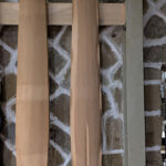 Rough-shaped guqin hanging on the wall next to others in progress.